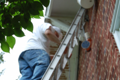 Painting technician scraping and cleaning bad surfaces in Northern Virginia